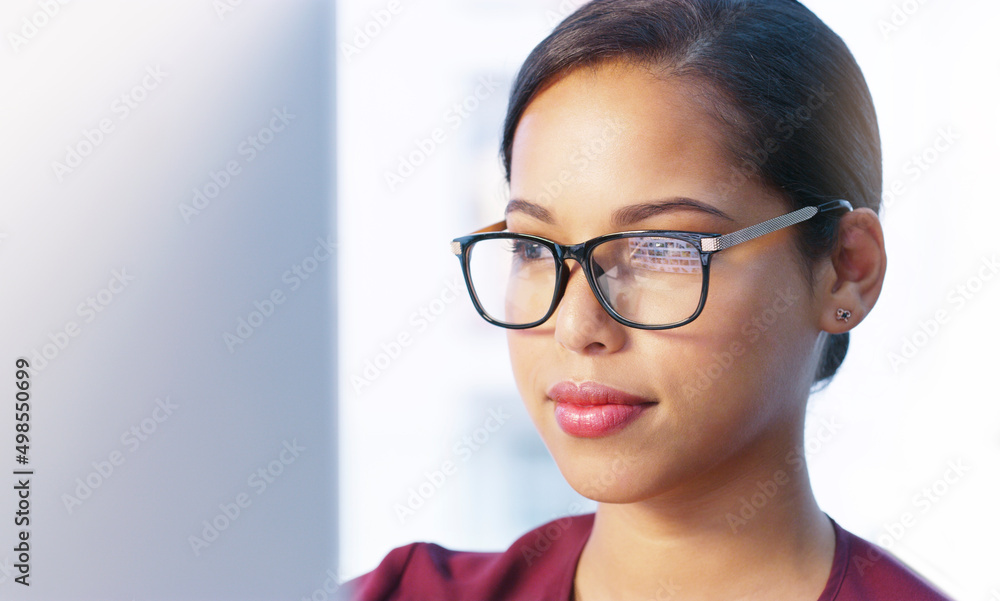 She is on a bright path in this company. Cropped shot of a focused young businesswoman working on her computer inside of the office. She is on a bright path in this company. Cropped shot of a focused young businesswoman working on her computer inside of the office.