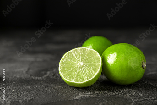 Lime, juicy ripe citrus fruits on a dark background. Ingredients for preparing refreshing drinks and cocktails. Mojito. side view and copy space