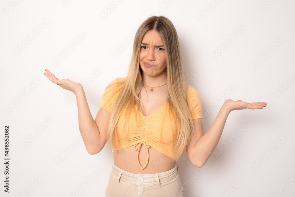 Portrait of a confused young casual girl shrugging shoulders isolated over white background Portrait of a confused young casual girl shrugging shoulders isolated over white background