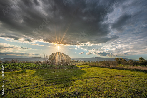 il sole tramonta dietro un rudere