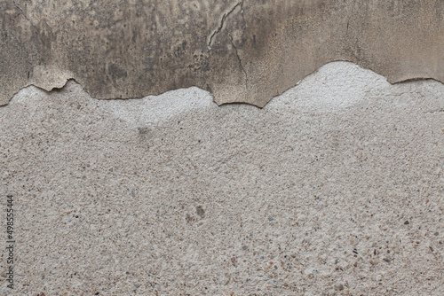 Old grey stucco wall with cracked plaster. Background texture