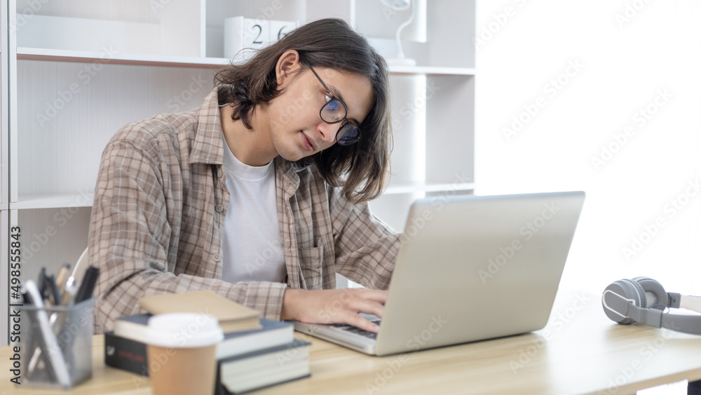 Young studying online uses his laptop in a live performance to communicate with his friends and teachers, Using laptops and data graphs in class, Online communication, Social distancing.
