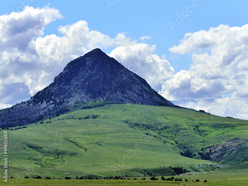 Haystack Butte in Montana is a background for several sections of grazing land. Cattle dot the area.
