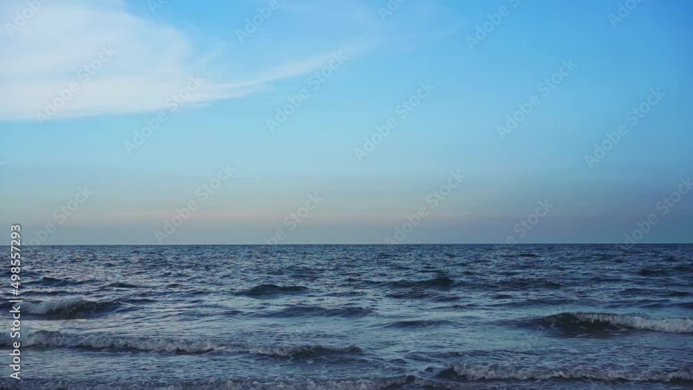 Golden sunset on a beach - slow motion of foamy blue ocean waves rolling towards sand beach under low the sun light. beautiful seamless never ending footage while waves breaking on sandy coastline. Golden sunset on a beach - slow motion of foamy blue ocean waves rolling towards sand beach under low the sun light. beautiful seamless never ending footage while waves breaking on sandy coastline.