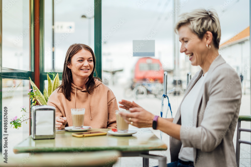 Fototapeta premium Two female friends drinking coffee and enjoying time
