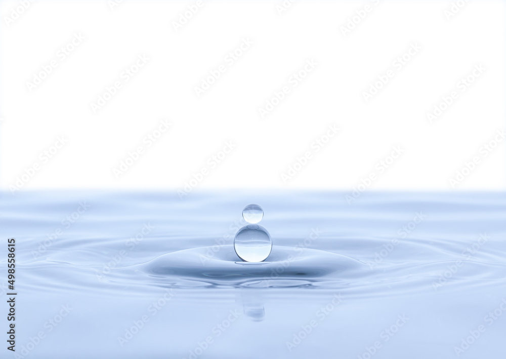 Splash and a ball of water on a blue background. Reflection on the surface of the water. Splash and a ball of water on a blue background. Reflection on the surface of the water.