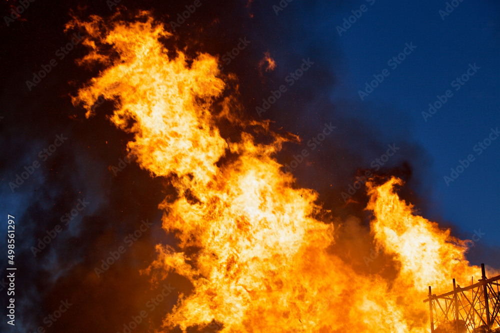 Raging flames of huge fire at night. Firestorm close up. Burning fire full frame. Bright inferno flames. Hell fire explosion. Blaze fire texture. Burning bright Bonfire. Intense combustion and heat.