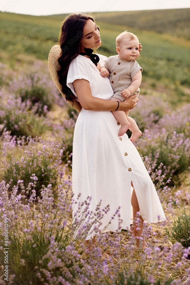 attractive young mother playing with her baby in a lavender field attractive young mother playing with her baby in a lavender field