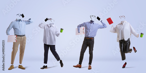 Four stylish invisible persons wearing modern business style outfits and eyeglasses standing against blue background. Concept of fashion, style