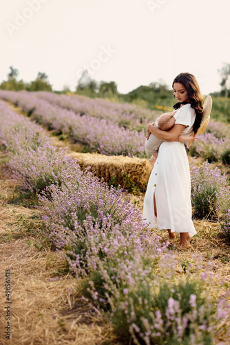 beautiful young mother breastfeeding baby in a lavender field
