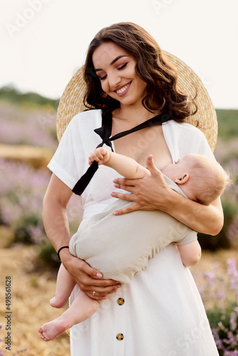 beautiful young mother breastfeeding baby in a lavender field