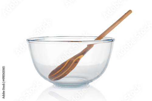 Empty glass food bowl with wooden spoon isolated on white background