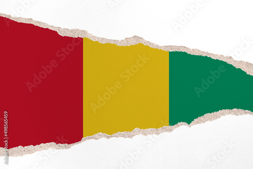 Ripped paper background in colors of national flag. Guinea