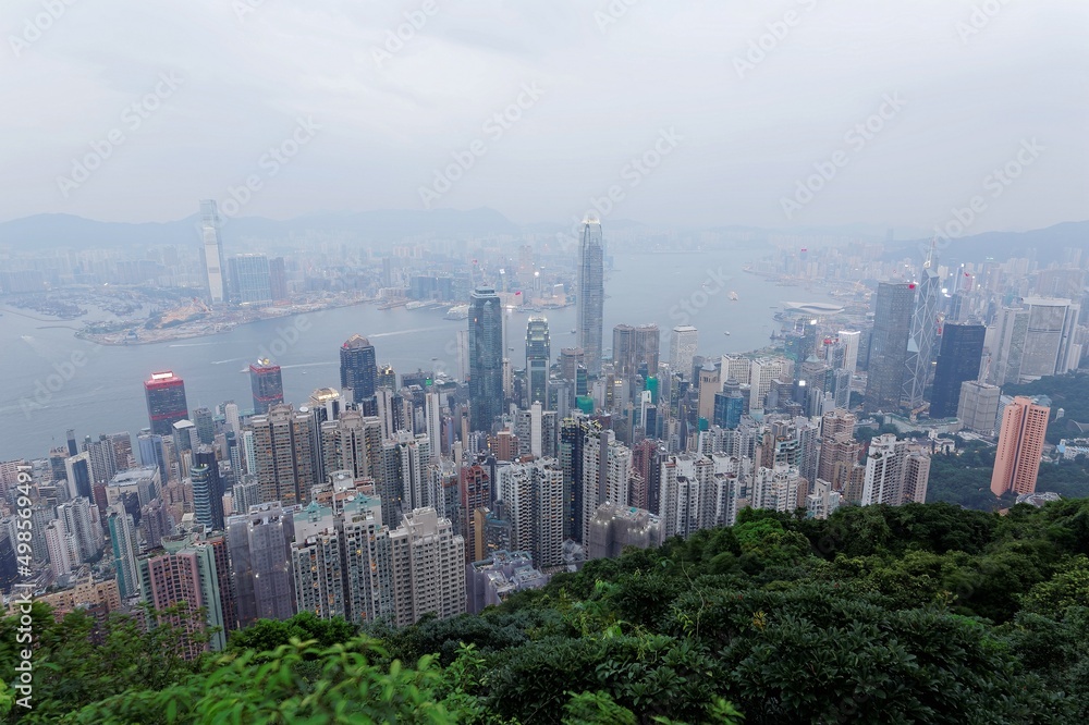Scenery of Hong Kong viewed from top of Victoria Peak in hazy dusk with city skyline of crowded skyscrapers by the harbour and Kowloon, with air pollution level classified as 
