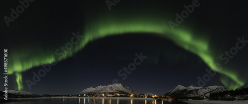 Aurora Borealis over Carcross, Yukon Canada with Bennett lake and reflecting lights