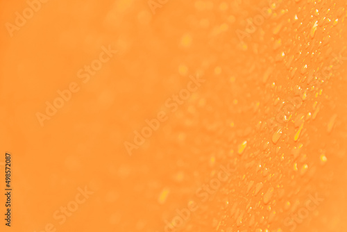 Yellow smooth surface with drops of water as textural background