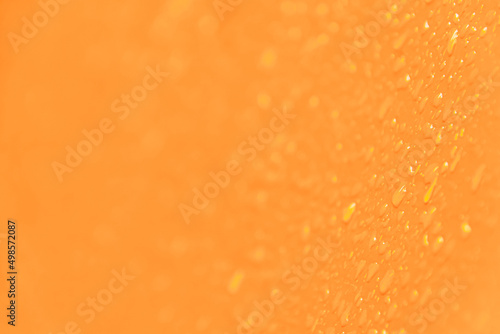 Yellow smooth surface with drops of water as textural background