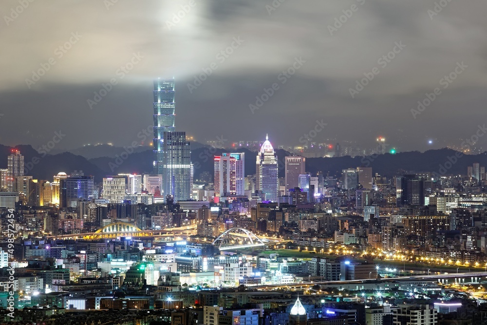Aerial view of Taipei City with Taipei 101 tower standing tall into clouds, and Keelung River and skyscrapers in downtown area in evening twilight ~ Scenery of foggy Taipei City with polluted hazy air