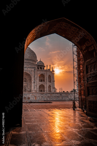 Fotobehang Vertical of a scenic view of the Taj Mahal Mausoleum at sunset through the archw