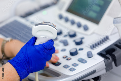 Close up of ultrasonography equipment holding ultrasound probe with coupling gel prepare for scanning. photo