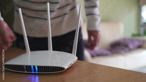 Selective focus at router. Internet router on working table with blurred man using tablet at the background. Fast and high speed internet connection from fiber line with LAN cable connection.