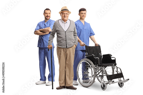 Elderly male patient and two health care workers with a wheelchair