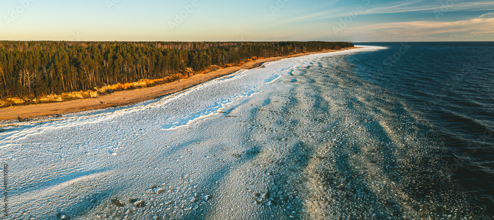 Scenic landscape of shore of Baltic sea at winter. Snow on sand.