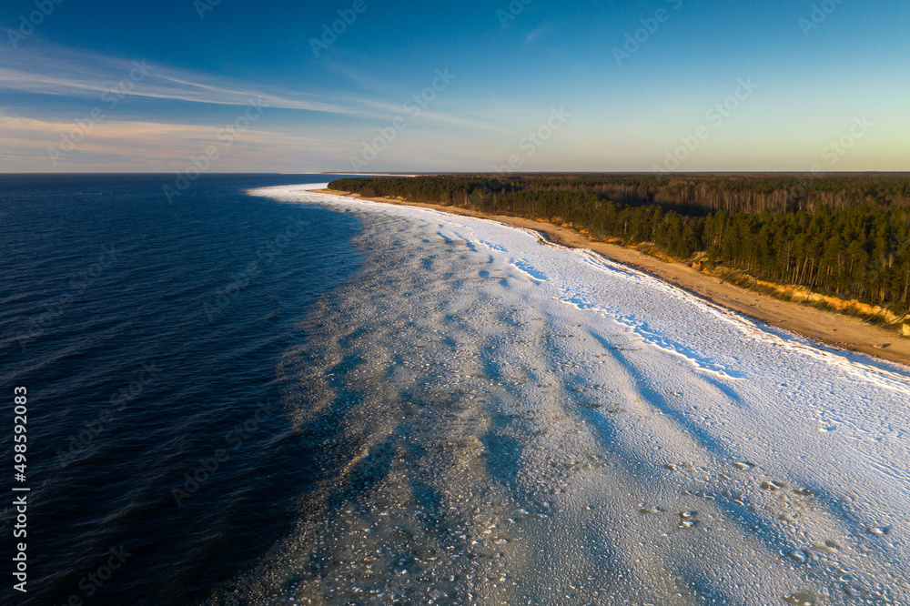 Scenic landscape of shore of Baltic sea at winter. Snow on sand.