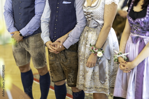 Closeup of traditional german clothes- lederhosen and dirndl dress at the wedding ceremony photo