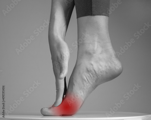 Pain in ball of foot. Woman holding leg with red spot closeup. Ache in metatarsal heads. Intense physical activity, inflammation consequences. Health care and medicine concept. High quality photo