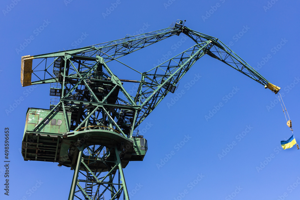 Old shipyard crane with the Ukrainian flag Old shipyard crane with the Ukrainian flag