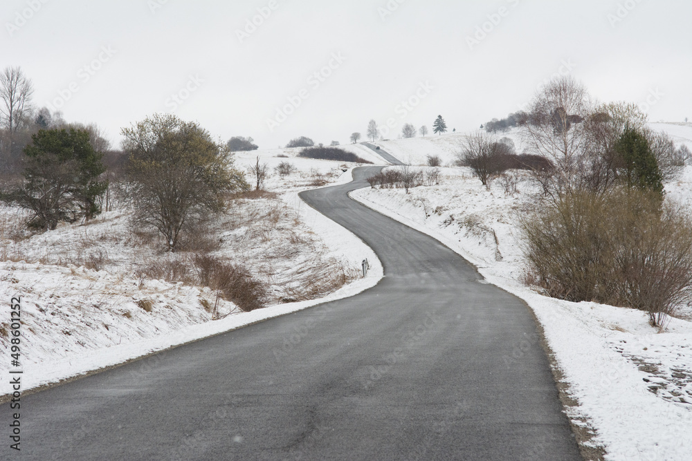 Winter landscape with a road winding between hills