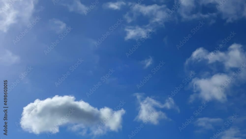Fast-running white clouds across a clear blue sky time-lapse. Cloudscape background. Time-lapse Moving abstract background. Fast-running white clouds across a clear blue sky time-lapse. Cloudscape background. Time-lapse Moving abstract background.