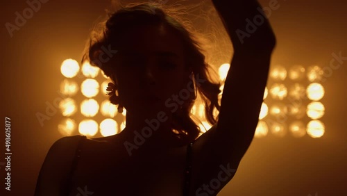 Beautiful lady dancing sexually in night club closeup. Sexy girl touching hair.