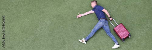 Photography Young man with suitcase walking on green grass top view