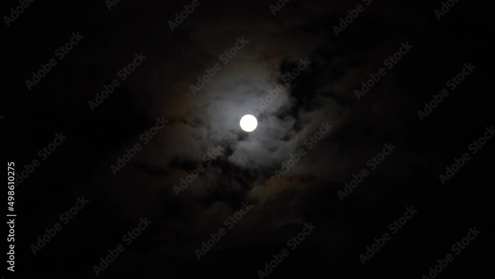 Clouds passing by full moon at night dark black sky, time lapse. Full moon rise in dark nature sky, night time Clouds passing by full moon at night dark black sky, time lapse. Full moon rise in dark nature sky, night time