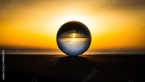 glass sphere on the water yellow sunrise