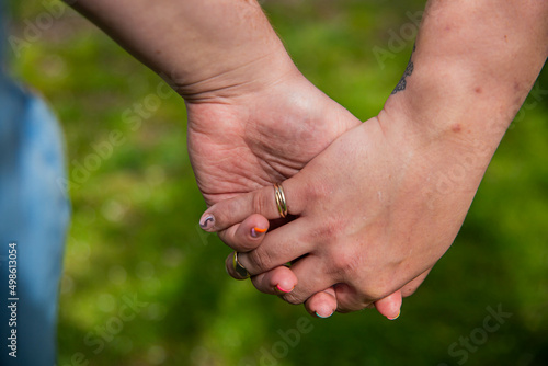 Lesbian couple holding hands. © Shingi          Rice