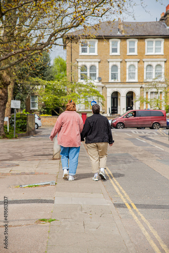 Lesbian couple walking holding hands.