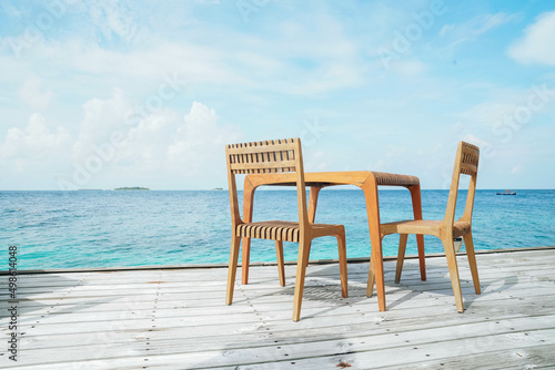 Outdoor terrace with Empty  wooden table and chair with Sea view of Indain ocean, Maldives background © Ruthsarintre