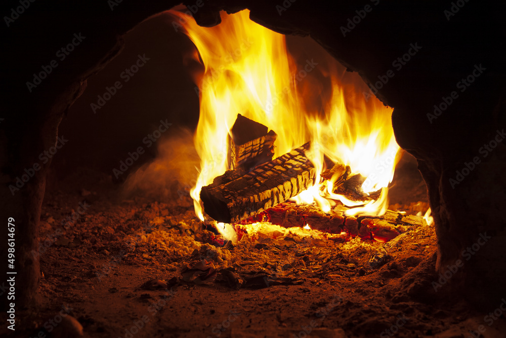Flaming wood in an open oven, burning firewood in a fireplace Flaming wood in an open oven, burning firewood in a fireplace