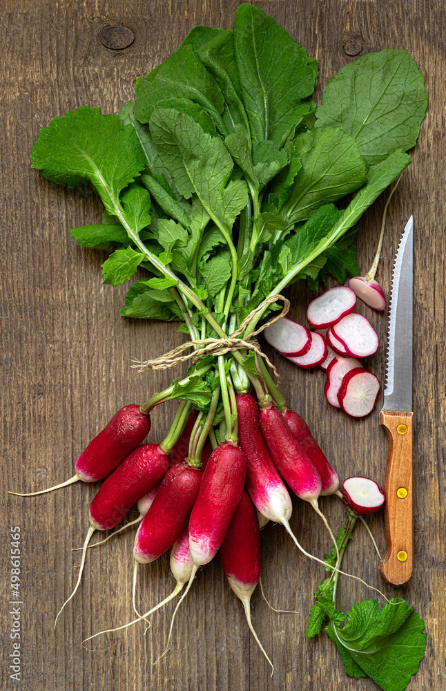 Fresh bunch of radish and knife on wooden table. Close-Up snapshot. Organic and healthy food concept. Fresh bunch of radish and knife on wooden table. Close-Up snapshot. Organic and healthy food concept.