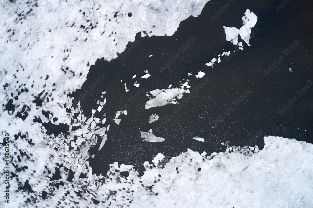 Polynya with ice floes on an ice-bound pond. Shooting from a drone.
