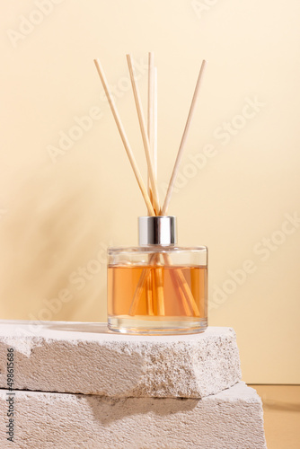 reed diffuser bottle on the podium. Incense sticks for the home with a floral scent with hard shadows. The concept of eco-friendly fragrance for the home photo
