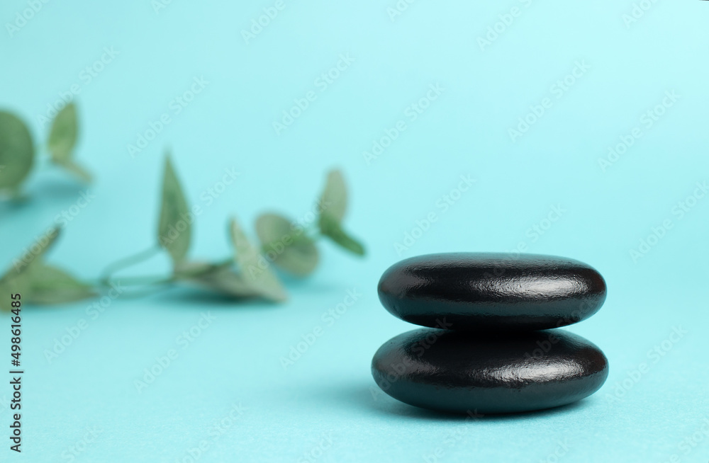 A stack of black zen balance stones on a blue background. The concept of a SPA center. A stage for promotion, sale, presentation or cosmetics. Copy space A stack of black zen balance stones on a blue background. The concept of a SPA center. A stage for promotion, sale, presentation or cosmetics. Copy space