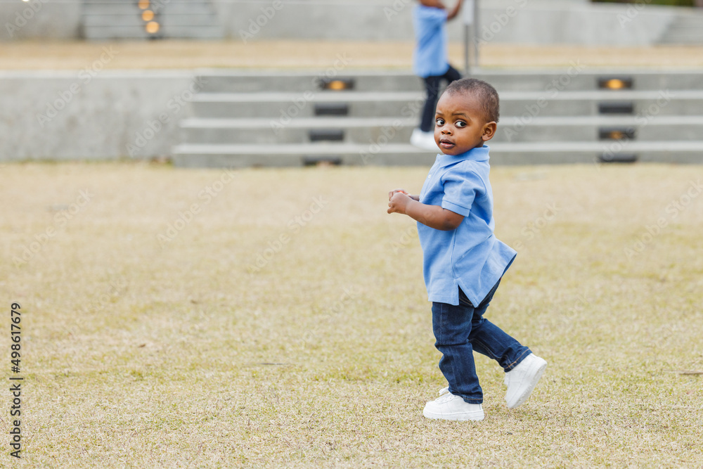 A cute one year old toddler running outside