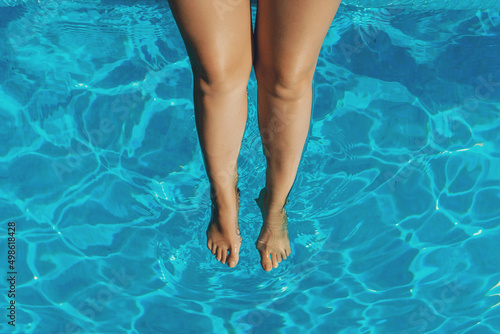 Female legs. Woman sitting near the pool.