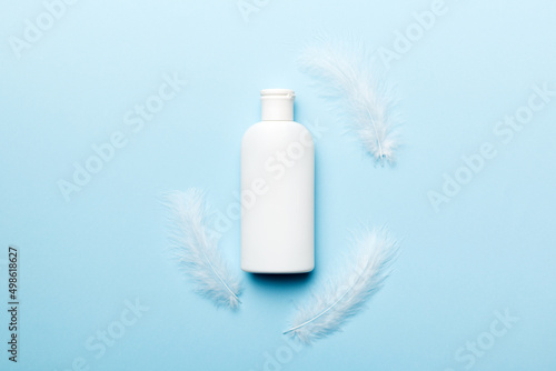 Spa cosmetic product, cream jar, branding mock up, top view with feathers background. Flat lay photo