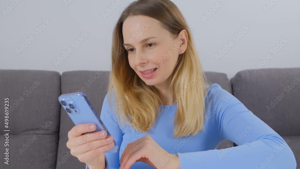 Woman browsing app on smart phone. Happy blond female using mobile application Woman browsing app on smart phone. Happy blond female using mobile application