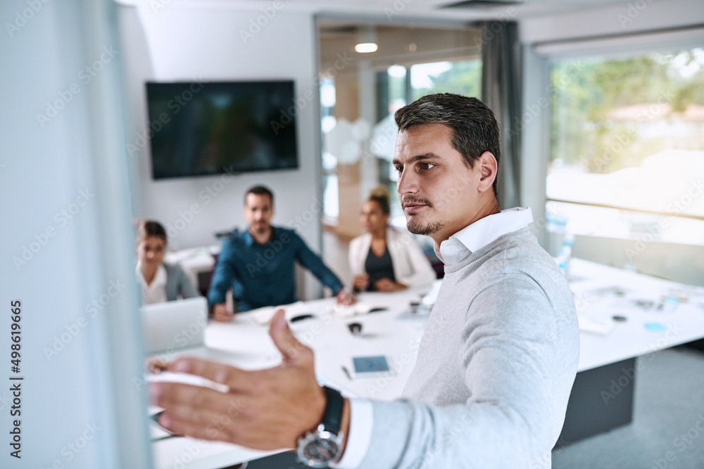 Stepping up to put ambition into action. Shot of a young businessman giving a presentation to his colleagues in an office. Stepping up to put ambition into action. Shot of a young businessman giving a presentation to his colleagues in an office.